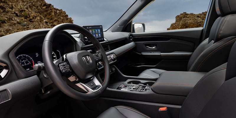 Front interior view of SUV showing steering wheel, dashboard, and center console.