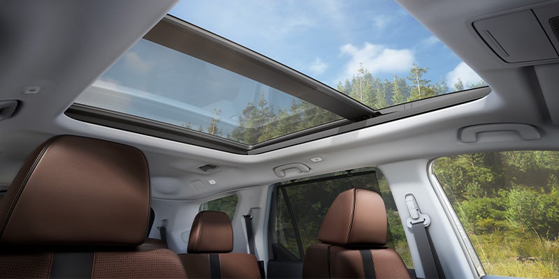 Interior view of SUV showing panoramic sunroof and brown leather seats.