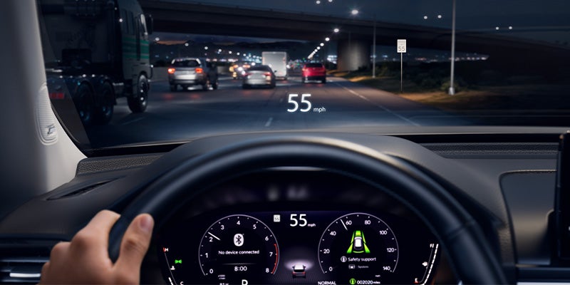 Driver’s view of Honda Pilot dashboard at night showing 55 mph on highway.