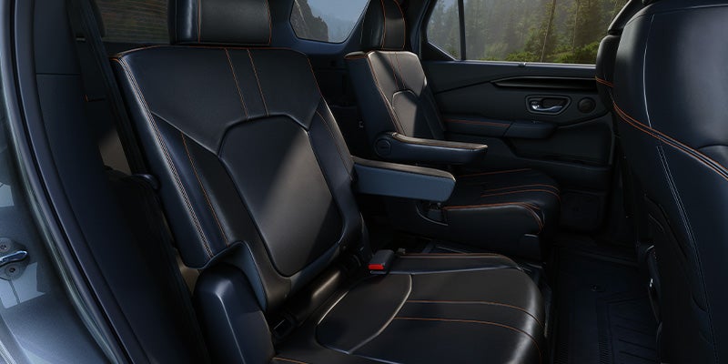 Rear passenger seats in SUV interior with black leather upholstery.