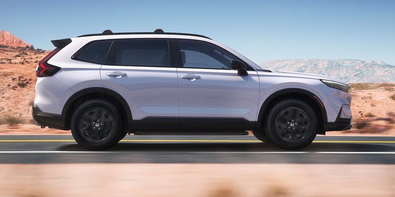 Side view of the 2026 Honda CR-V driving on an open road.