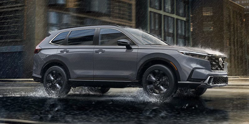 2026 Honda CR-V navigating through wet streets in a city environment.