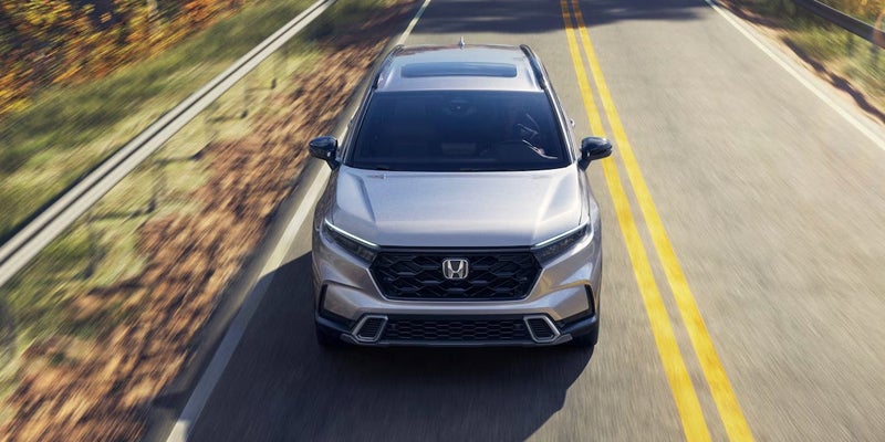 2026 Honda CR-V driving on a scenic road from an overhead perspective.