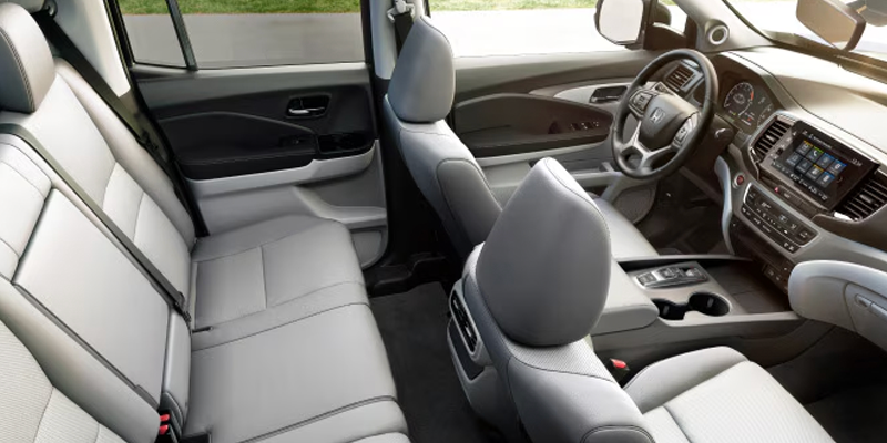 Honda Ridgeline interior showing front and rear seats in gray upholstery.